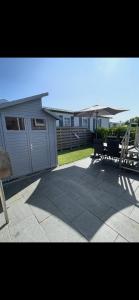 a patio with a shed and a bench and some houses at Chalet Home Texel in De Koog +16 photos