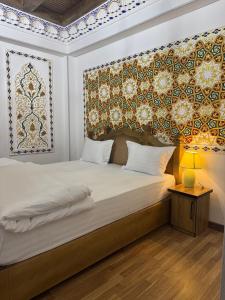 Schlafzimmer mit einem Bett mit einem Kopfteil und einem Tisch in der Unterkunft Central asia hotel in Muruntau