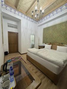 ein Schlafzimmer mit einem großen Bett und einem Tisch in der Unterkunft Central asia hotel in Muruntau