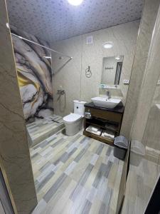a bathroom with a sink and a toilet and a mirror at Central asia hotel in Muruntau
