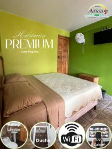 a bedroom with a bed and a green wall at Hotel Adulam in San Pedro La Laguna