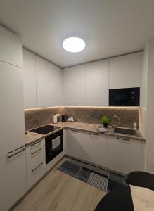 une cuisine avec des armoires blanches et un évier dans l'établissement SADBA Apartment, 1-4 guests, Free Parking & Wifi, 15 min from Downtown, à Bratislava