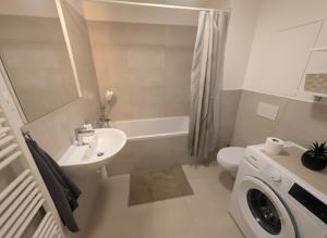 une salle de bain avec un lavabo et des toilettes et une machine à laver dans l'établissement SADBA Apartment, 1-4 guests, Free Parking & Wifi, 15 min from Downtown, à Bratislava 7 autres photos