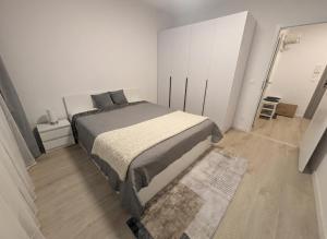une chambre avec un lit dans une pièce blanche dans l'établissement SADBA Apartment, 1-4 guests, Free Parking & Wifi, 15 min from Downtown, à Bratislava