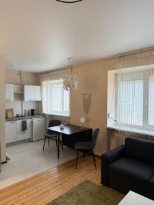 Una cocina y una sala de estar con mesa y sillas. en Paupys Cozy Studio, en Vilna