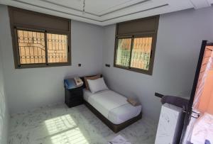 a small bedroom with a bed and two windows at Relax House in Ikhorbane