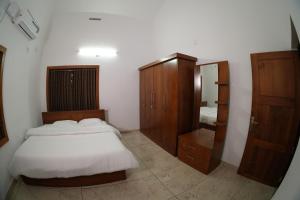 Un dormitorio con una cama, una cómoda y un espejo. en The Kayal Delight, en Cheruvattūr