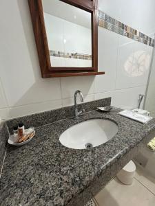 a bathroom counter with a sink and a mirror at Pousada Sinhá Moça Campos Ltda in São João del Rei