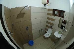 Baño pequeño con 2 aseos y lavamanos en The Kayal Delight, en Cheruvattūr