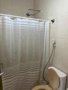 a bathroom with a shower curtain and a toilet at Casa em Itamaracá - 70 metros da Praia in Itamaracá +25 photos