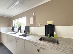 ワナカにあるMt Aspiring Holiday Parkのキッチン(シンク2台、カウンタートップ付) +17枚の写真