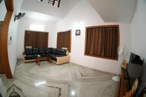 Una sala de estar con un sofá negro y una mesa. en The Kayal Delight, en Cheruvattūr 32 fotos más