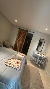 a bedroom with a bed and a table and a door at Casa Riachuelo in Genuino Sampaio