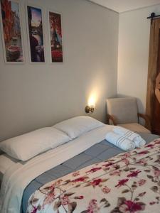a bedroom with a bed and a chair and pictures on the wall at Casa Riachuelo in Genuino Sampaio