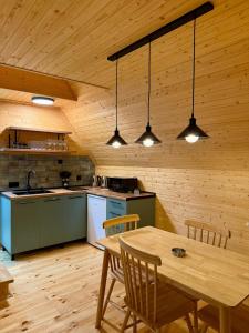 a kitchen with a table and chairs and lights at Mestia POV Luxury Cabins in Mestia