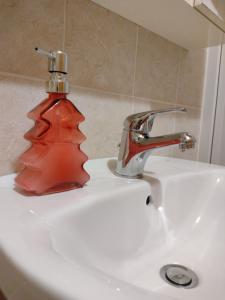 un distributeur de savon rouge posé sur un évier dans l'établissement sax & rosa, à Pigna 40 autres photos