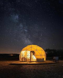 una gran tienda de campaña tipo domo bajo un cielo estrellado por la noche en MOON RUM lUXURY CAMP, en Wadi Rum