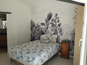 a bedroom with a bed and a wall with plants at Studio calme 15 min Aix en Provence in Éguilles