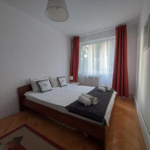 a bedroom with a large bed with red curtains at Sunflower apt in Timişoara