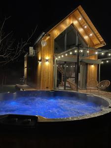 a large tub in front of a house at night at Wyspa Roztocze in Kulików