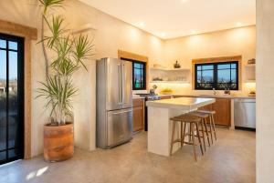 Boutique Villa Featured on Emmy-Award Winning StayCation في تودوس سانتوس: مطبخ مع ثلاجة ستيل ستانلس وكاونتر