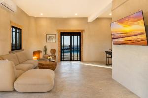 Boutique Villa Featured on Emmy-Award Winning StayCation في تودوس سانتوس: غرفة معيشة مع أريكة وتلفزيون