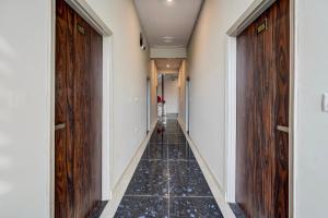 a hallway with wooden doors and a tile floor at Collection O Kesar Crossway Jaipur Formerly Laxmi Palace in Jaipur