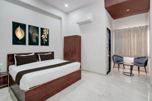 a bedroom with a bed and a desk and a chair at Collection O Kesar Crossway Jaipur Formerly Laxmi Palace in Jaipur