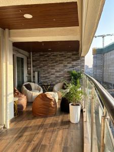 Un balcón con sillas y mesas en un edificio. en Luxury Aesthetic Party Pad, en Bombay