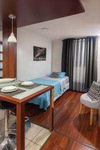 une chambre avec un lit et une table et une salle à manger dans l'établissement Departamentos Merced, à Santiago