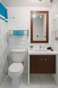 une salle de bain avec toilettes, lavabo et miroir dans l'établissement Departamentos Merced, à Santiago