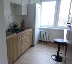 a small kitchen with a sink and a stool in it at Apartament na Manhattanie in Toruń