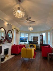 カーライルにあるLynebank House Hotel, Bed & Breakfastの赤と黄色の椅子と暖炉のあるリビングルーム
