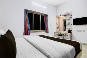 Un dormitorio con una cama y un televisor y una ventana. en Hotel O Aditi Guest House, en Salt Lake City