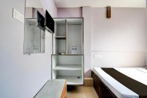 a small room with a bed and a tv at Hotel O Sharan Guest House in Calcutta Bara Bazar