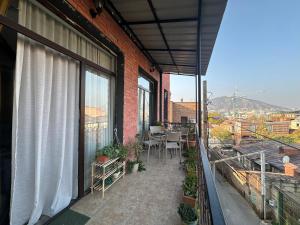 第比利斯A p a r t m e n t AnnaMari O l d T b i l i s i的大楼内带桌椅的阳台