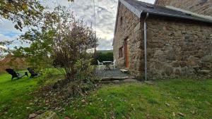 a stone building with a table and a bench next to it at Les gîtes de la salamandre in Callac