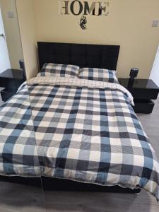 a bed with a blue and white checkered blanket at Delta Valley in Forest Hill