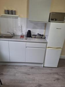 a white kitchen with a sink and a refrigerator at Delta Valley in Forest Hill