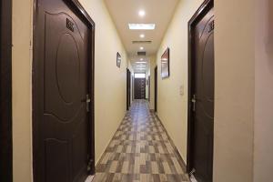 a hallway with two brown doors and a tile floor at Super Hotel O Raj Palace in Meerut
