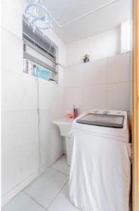 a white bathroom with a toilet and a sink at Casa Branca 355 Familiar in Rio de Janeiro