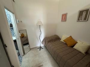 un soggiorno con un divano e una lampada di Alojamiento De Rocha a Monte Grande