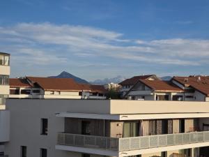 eine Gruppe von Gebäuden mit Bergen im Hintergrund in der Unterkunft Le Chaleureux in Annemasse