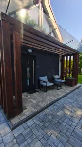 a patio with two benches in front of a building at Domek PodMaglem in Glinik Polski +9 photos