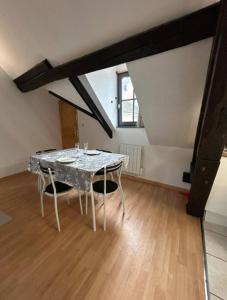 a dining room with a table in a attic at L'Envolée Mansardée - Center in Chartres