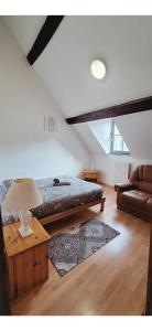 a bedroom with a large bed and a couch at L'Envolée Mansardée - Center in Chartres