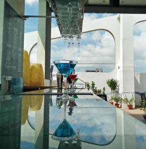 a glass table with two glasses on top of it at Hotel Senses in Kolkata