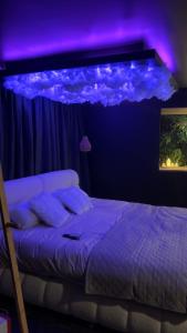 a bedroom with a bed with a purple lighting at Ecrin secret in Aubagne