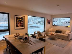 a living room with a table and a couch at Luxury Panorama Apartment by the Sea with Northern Lights View in Tromsø