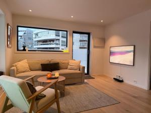 a living room with a couch and a table at Luxury Panorama Apartment by the Sea with Northern Lights View in Tromsø